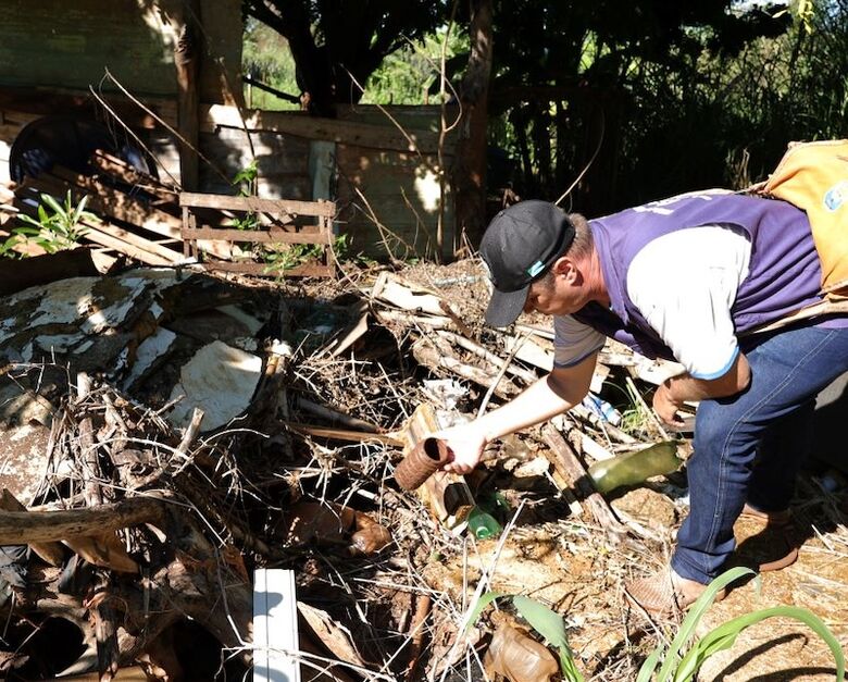 Agente manipula recipiente com água parada