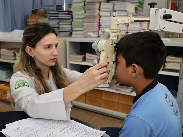 Criança passa por exame visual em escola