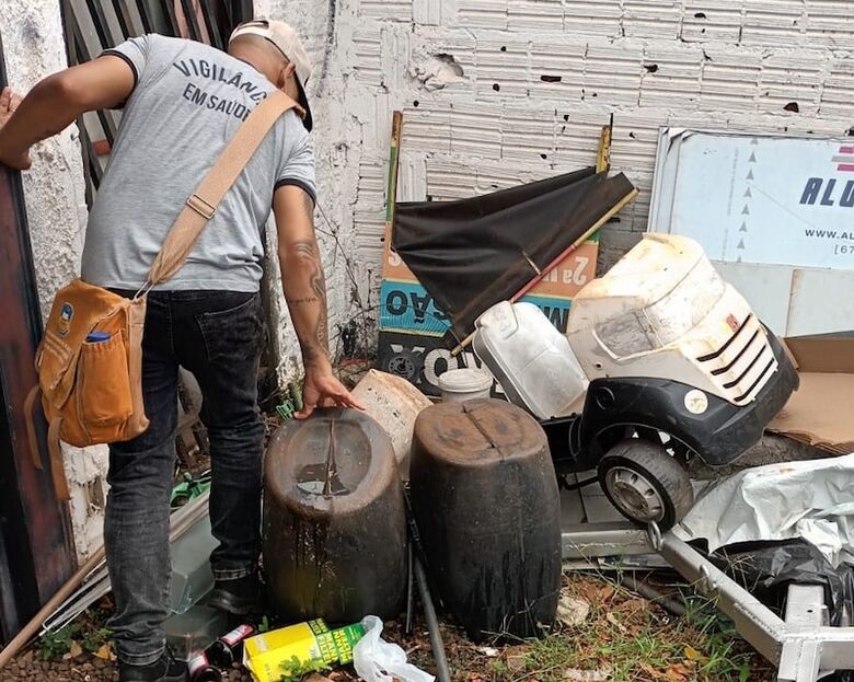 Agente de Saúde inspeciona resíduos acumulados em quintal