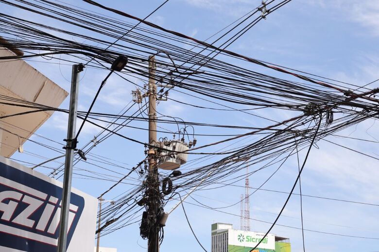 Emaranhados de fios nos postes da rede de energia oferecem riscos à população e causam poluição visual na cidade
