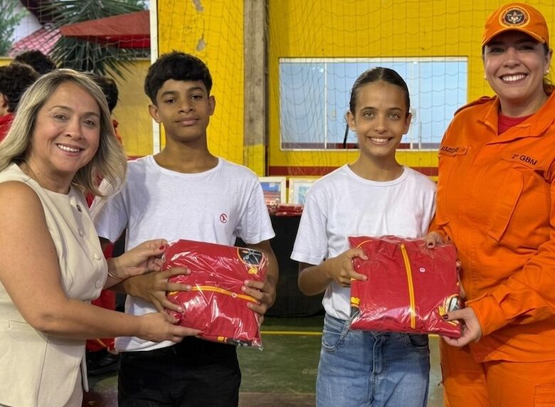 Lia, com a comandante Karoline, entregando uniformes